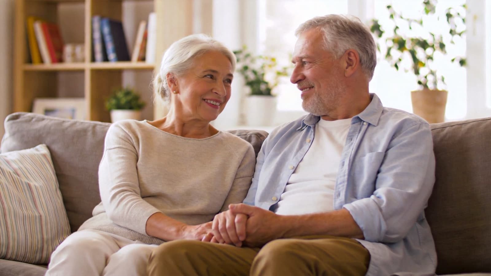 Couple de seniors propriétaires sereins dans le salon de leur logement